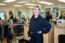 Dr. Sally Vinden stands inside a hair salon classroom