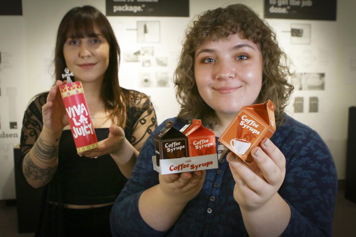 Rebecca Hanelt, left, and Chantelle Calitz, VIU Graphic Design students, hold up the packaging designs they created for the art exhibit Unwrapped at The View Gallery. Rebecca Hanelt, left, and Chantelle Calitz, VIU Graphic Design students, showcase their environmentally sustainable packaging redesigns during the art exhibit Unwrapped at The View Gallery.