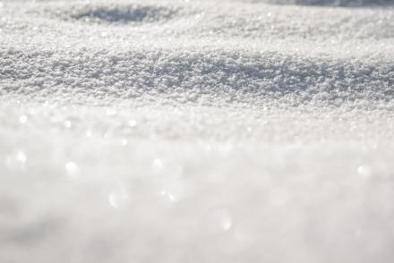 A closeup of snow with the sun shining on it.